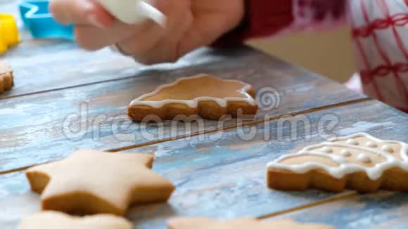 为圣诞节做姜饼饼干女人饼干上涂着白釉的手画视频的预览图