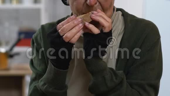 无家可归的老妇人用握手吃面包低收入者视频的预览图