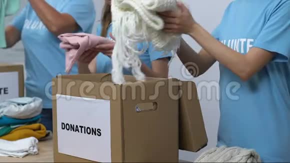 一群志愿者把衣服装在盒子里友好的女士微笑着对着镜头视频的预览图