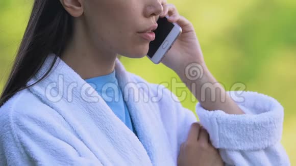 穿着浴袍的女人在户外说电话坏消息健康问题视频的预览图