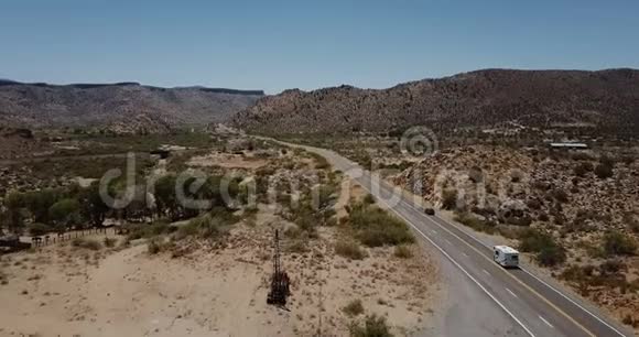 美丽的电影空中镜头汽车和露营车驾驶在阳光明媚的沙漠山道在美国旅行旅行旅行冒险视频的预览图