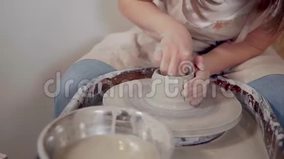 女陶工正在车间的陶工轮上制作陶工陶杯视频的预览图