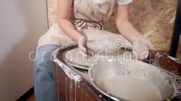 女人正在从陶工的轮子上取一个形状的陶土碗特写镜头视频的预览图