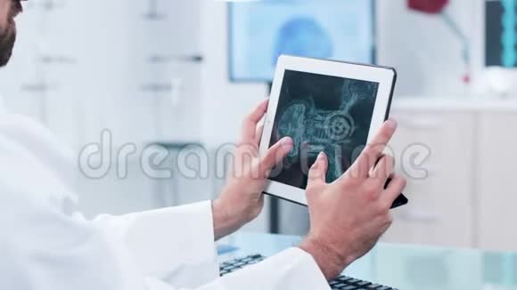医生在数码平板电脑屏幕上观察和分析X光视频的预览图