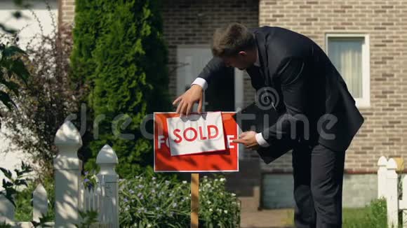 男性房地产经纪人设置出售标志显示是手势成功交易视频的预览图