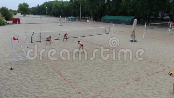 四名女子在沙滩上打排球的空中镜头4k视频的预览图