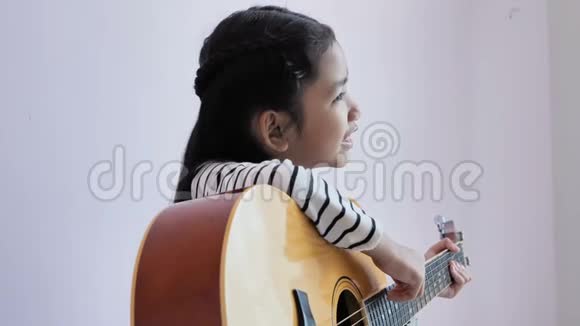 穿着黑白条纹裙子的女孩弹吉他唱歌视频的预览图