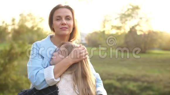 可爱的一对妈妈和女儿在秋天的城市公园拥抱母爱少女视频的预览图