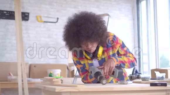 非洲女人留着非洲发型在车间里靠木头工作视频的预览图