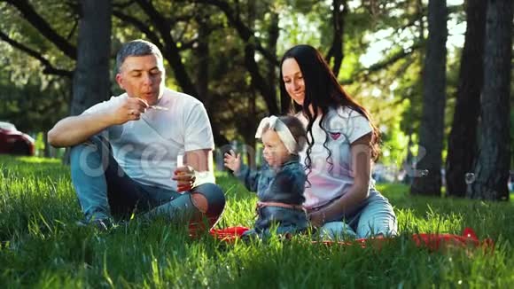 爱的家庭和女婴享受夏天在公园吹肥皂泡视频的预览图
