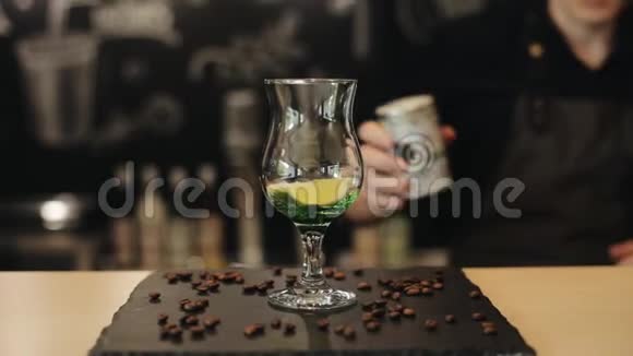 男性咖啡师的手通过将糖粉加入到带有绿色糖浆石灰和薄荷的玻璃杯中来制作莫吉托视频的预览图
