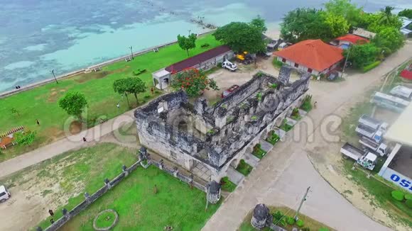 航空飞行菲律宾宿务平静的蓝海海滩前历史西班牙地标遗址的全景视频的预览图