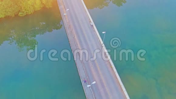 驾驶飞机飞过一座路桥和一座绿色小镇视频的预览图
