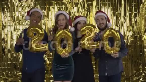 2020年落下的金色纸屑4个带着金箔字母的人在金色的背景上跳舞红色视频的预览图