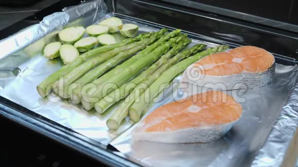 烤箱煮蔬菜的过程新鲜的西红柿甘蓝和绿芦笋放在烤箱托盘上健康饮食支票视频的预览图