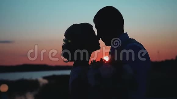 两个情人的剪影背景是凉爽美丽的日落很好的计划视频的预览图