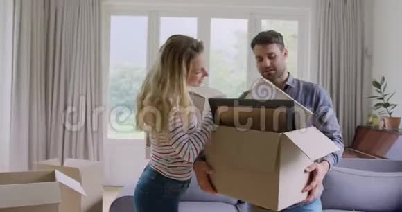 一对夫妇拿着纸板箱在新家里互相交流视频的预览图