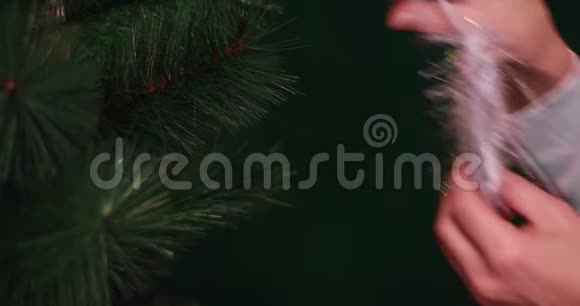 女手把新年玩具挂在圣诞树上圣诞节和圣诞老人视频的预览图