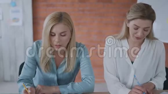 两名妇女正在从事一个项目女孩们在平板电脑上看报告现代办公团队合作理念4克视频的预览图
