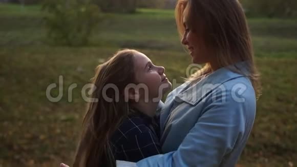 少女和她妈妈在秋天公园散步时玩得很开心快乐的家庭假期视频的预览图