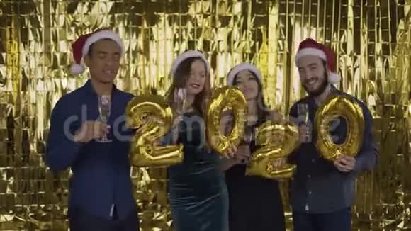 2020年落下的金色纸屑4个带着金箔字母的人在金色的背景上跳舞红色视频的预览图