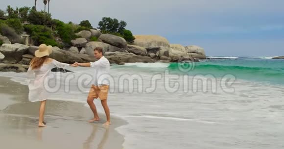 高加索夫妇手牵手在海滩4k的侧景视频的预览图