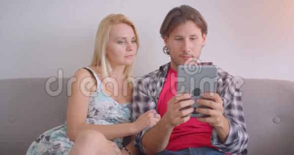使用平板电脑和显示绿色屏幕的成人白种人夫妇坐在一起的特写照片视频的预览图
