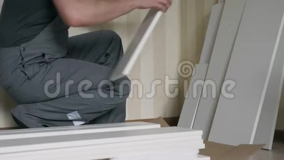 工人在组装前先把白色木制家具的部件拆开视频的预览图