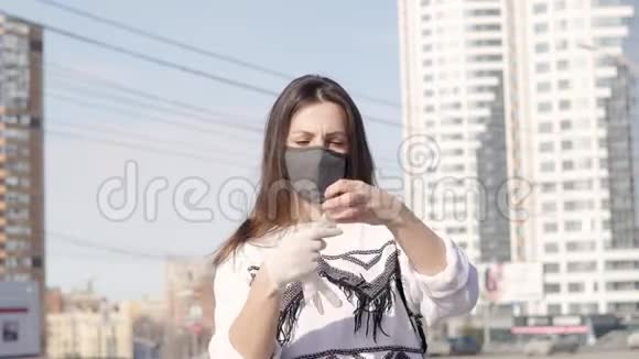 戴着医用口罩的城市背景的年轻女性戴着无菌手套视频的预览图