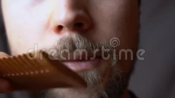 一个用梳子梳胡子的人视频的预览图