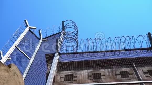 高的监狱围栏带刺铁丝网对抗晴朗的天空底部视图视频的预览图