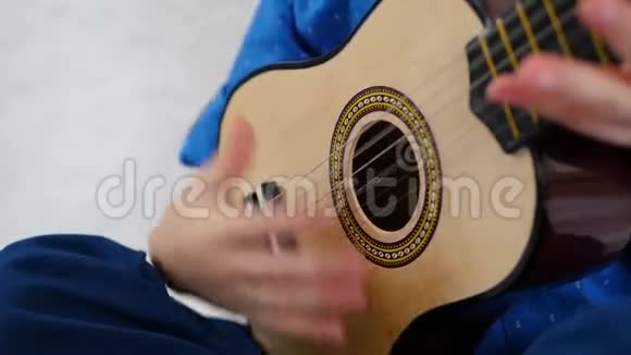 一个孩子在慢动作特写演奏儿童的吉他视频的预览图