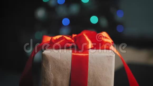 背景圣诞树上的棕色礼品盒和红色丝带视频的预览图
