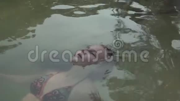 塞舌尔普拉斯林岛可爱的女孩躺在背上干净的水中放松地球上的天堂旅游放松视频的预览图