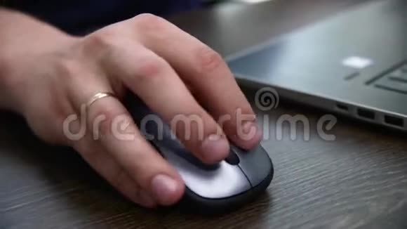 男人在笔记本电脑上工作用无线鼠标在桌子上特写视频的预览图