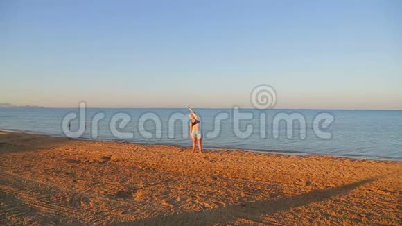 一个黑发女人正在海滨做伸展运动视频的预览图
