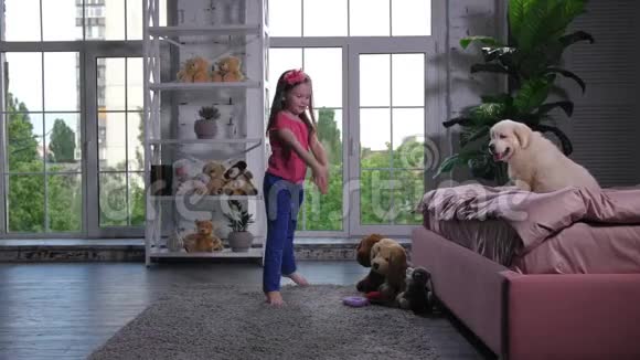 优雅的孩子为坐在床上的小狗跳舞视频的预览图