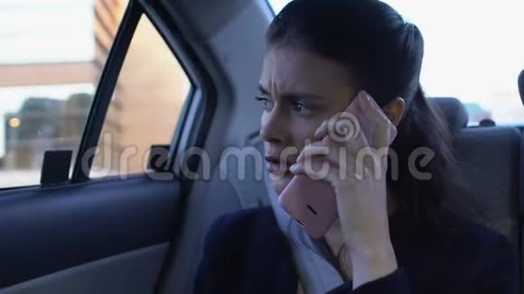 沮丧的女商人在车上用手机骂人工作负担过重视频的预览图
