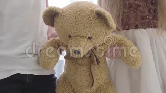 特写小男女白种人双手抱着泰迪熊两个朋友分享的软玩具视频的预览图