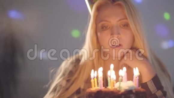 肖像可爱的金发女人吹着蛋糕上的蜡烛那个孤独的女孩有生日聚会庆祝概念视频的预览图