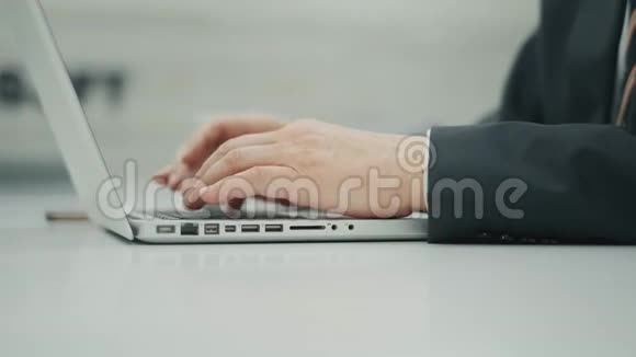 无法辨认的老人正在使用笔记本电脑并在键盘上打字商人坐在办公室里视频的预览图