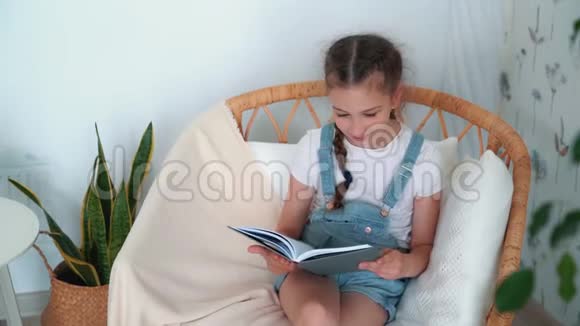 小女孩坐在扶手椅上拿着日记说些什么慢动作视频的预览图