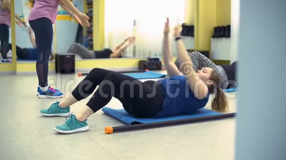 超重妇女在垫子上做身体训练视频的预览图