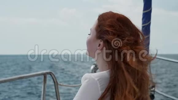 红头发的女孩坐在一艘在公海上航行的游艇上视频的预览图