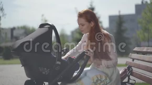 可爱的红发女人和她的孩子在公园的特写镜头里玩妈妈和她一起享受晴天视频的预览图