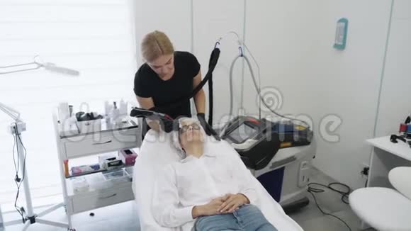 慢动作美容师用特殊设备做女孩面部血管激光切除术视频的预览图