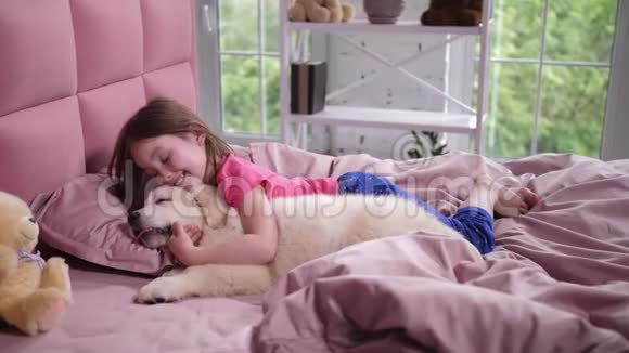 可爱的小女孩在卧室里醒来昏昏欲睡的小狗视频的预览图