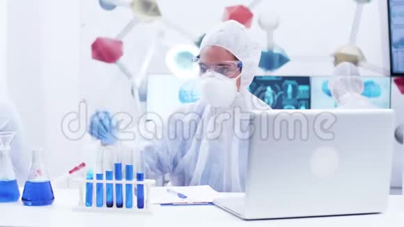 女性科学家拿着一支带蓝色烟液和书写公式的试管视频的预览图