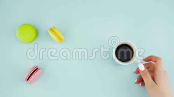 意大利马克龙或意大利马卡龙在粉蓝色表面与浓缩咖啡在白色杯和卡布奇诺在红色杯视频的预览图