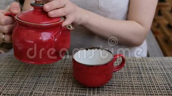 将中国绿茶从陶瓷壶中倒入香杯的手合上视频的预览图